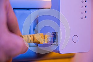 Man insert ethernet cable into WiFi extender device which is in