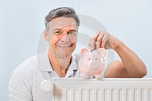 Man inserting coin in piggy bank