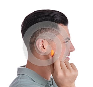 Man inserting foam ear plug on white background