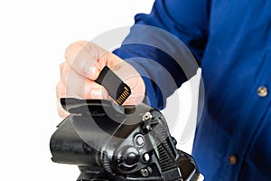 Man inserting a memory card in a reflex camera