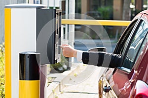 Man Inserting Ticket For Parking Area