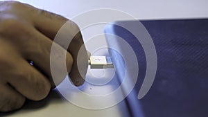 Man inserting usb cable into laptop