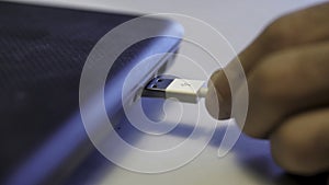 Man inserting usb cable into laptop. Media