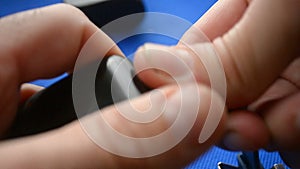 A man inserts a charger into a smart watch on dark blue background.Action for charging smart watch.