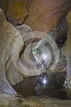 Man inside cave with headlight