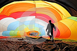 Man inside a colorful hot air balloon inflating