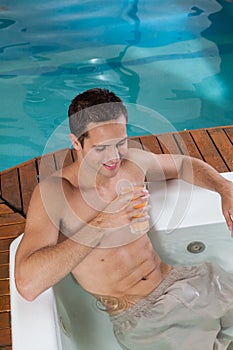 Man inside a jacuzzi drinking juice