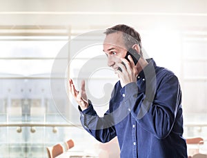 Man inside modern building wearing casual clothes and holding very emotional conversation