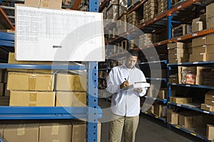 Man Inspecting Boxes In Warehouse