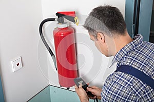 Man Inspecting Fire Extinguish