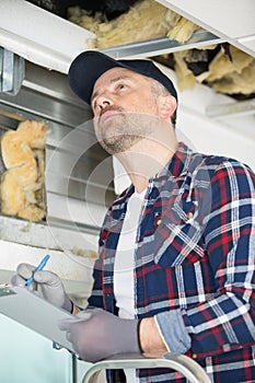 Man inspecting insulation in building
