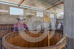 man inspecting the mezcal fermentation tanks photo