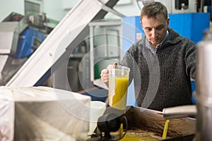 Man inspecting pressing of olive oil