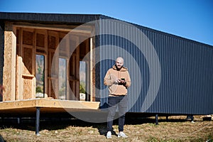 Man inspecting quality of building wooden frame house.