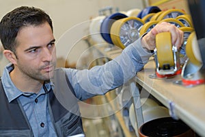 Man inspecting trolley wheels in factory