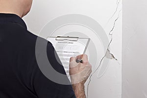 man inspection wall crack rip