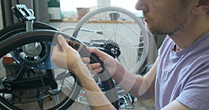 man inspects bicycle inner tube for punctures. Trying on a tire. Looks at the sealed patches. The concept of a home bike