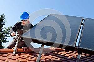 Man installing alternative energy photovoltaic pan