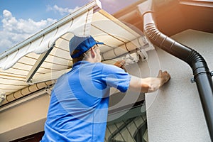 Man installing awning on house facade wall over the balcony photo