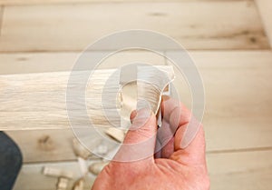 Man is installing the baseboard. Repair works indoors. Renovation in the flat