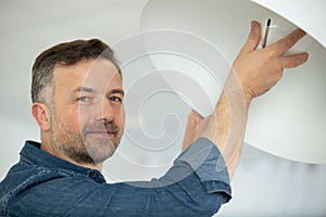 man installing bulb in living room at home