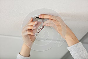 man installing bulb in living room at home