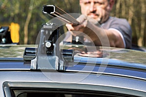 Man installing a car roof rack outdoors