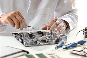 Man installing computer chip onto motherboard at white table, closeup