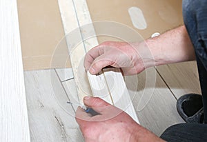 Man is installing the doors. Carpenter holding wooden plank in hands. Repair indoor works. Maintenance in the apartment
