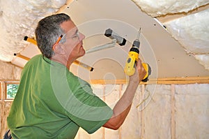 Man installing drywall on ceiling