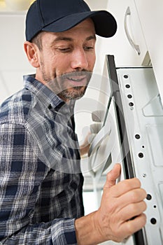 man installing eye-level oven