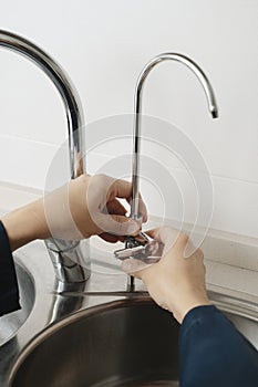 man installing a faucet in a kitchen sink