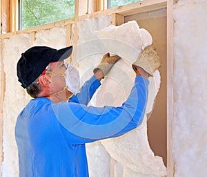Man installing fiberglass insulation photo