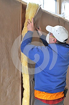 Man installing fiberglass insulation