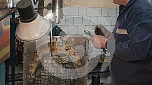 Man installing gear box of kamaz on a boring machine