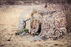 Man installing hunting tent in rural field