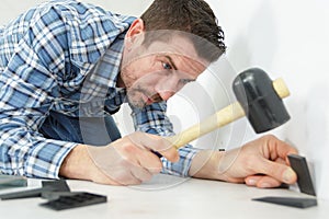 Man installing laminate flooring with insulation board