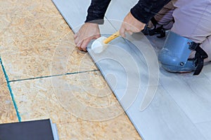 Man installing laminate flooring panel at new a home