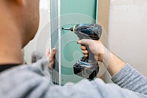 Man installing moisture resistant drywall sheets photo