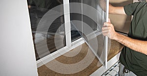 Man installing the mosquito net on the window