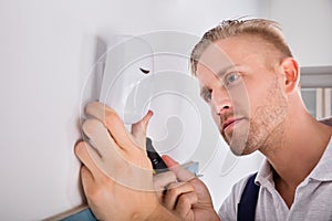 Man Installing Motion Detector For Security System