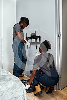 Man installing mount TV with screwdriver on wall at home