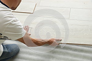 Man installing new laminate flooring, closeup view