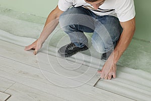 Man installing new laminate flooring indoors, closeup