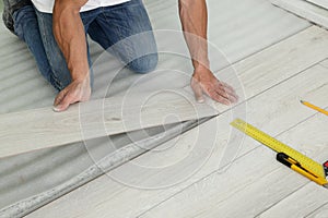 Man installing new laminate flooring indoors, closeup