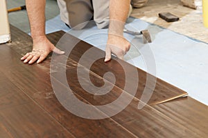 Man Installing New Laminate Wood Flooring