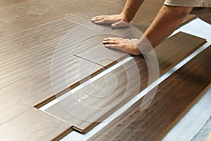 Man Installing New Laminate Wood Flooring photo