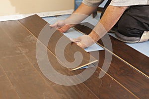 Man Installing New Laminate Wood Flooring photo