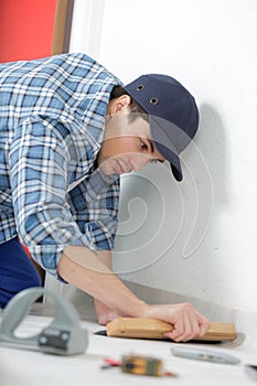 Man installing new laminate wood flooring abstract