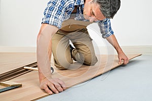 Man installing new laminated wooden floor